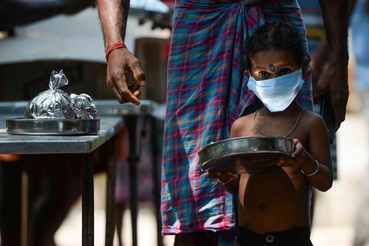 A migrant worker and his daughter wait to get food at a camp in Chennai on April 16. |PTI