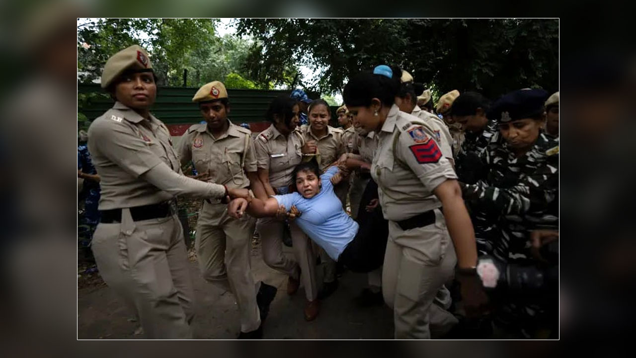 Olympic bronze medallist Sakshi Malik, in blue, is detained by police during a protest near the Indian Parliament in New Delhi on May 28, 2023